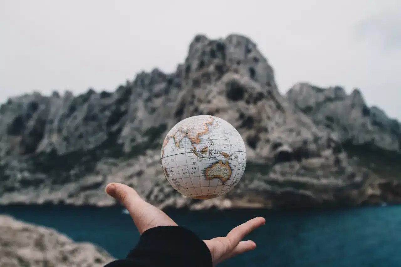 a globe floating above a person's hand