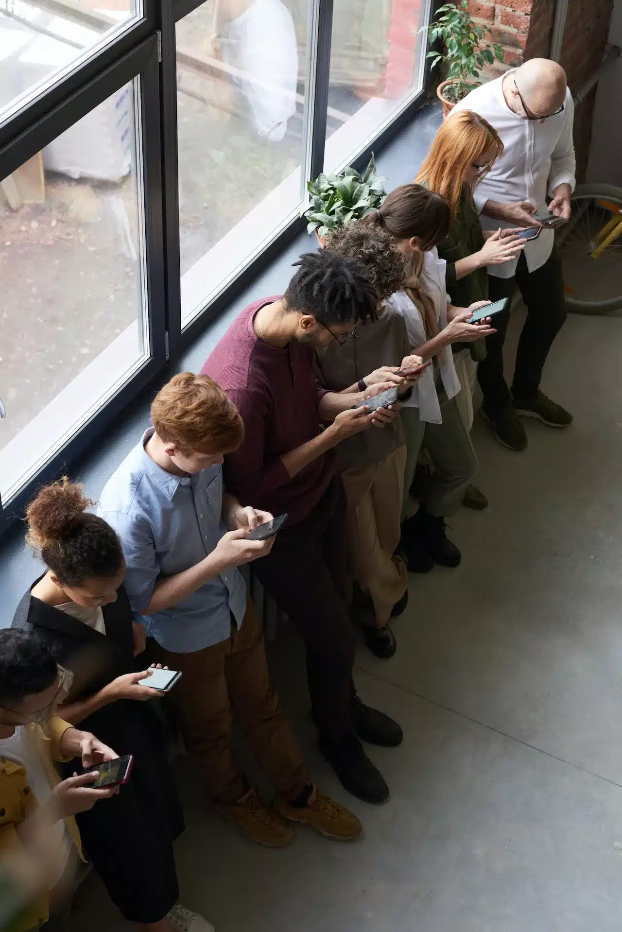 a line of people all viewing social media on their mobile devices